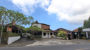 A street view with a building that has a small tower, a sign for ADA KAMAR, and a pharmacy sign. - Luxury Deluxe DBL Escape W/ Free WiFi and Parking (Yogyakarta)
