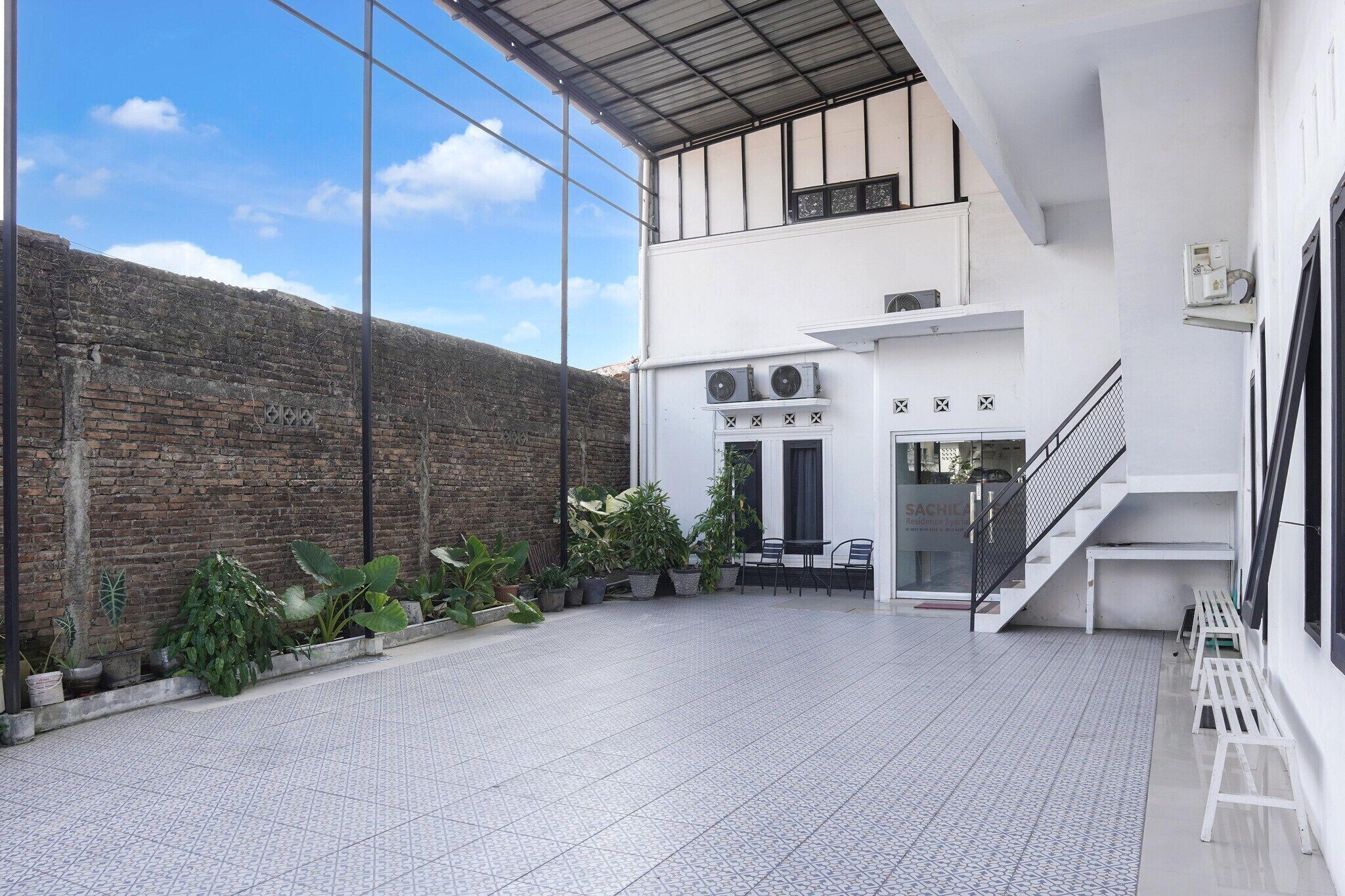 Un edificio moderno con piso de baldosas, pared de ladrillo y plantas en macetas.
