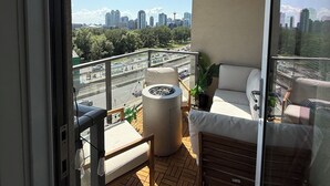 A balcony with a sofa, a small table, and a potted plant. - Luxury Bridgeland 2BR/2BA – King Suite, Saddledome/City Views & Parking (Calgary)
