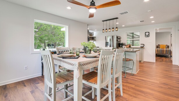 A modern kitchen with a dining area, wooden flooring, and a ceiling fan. - Bring Your Boats! Waterfront Retreat on PK Lake (Graford)
