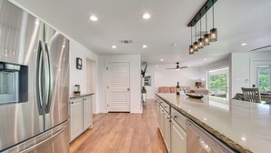 A modern kitchen with stainless steel appliances, wooden flooring, and a large island. - Bring Your Boats! Waterfront Retreat on PK Lake (Graford)