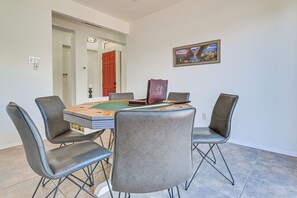 Uma sala de jantar com uma mesa, cadeiras e um quadro na parede.