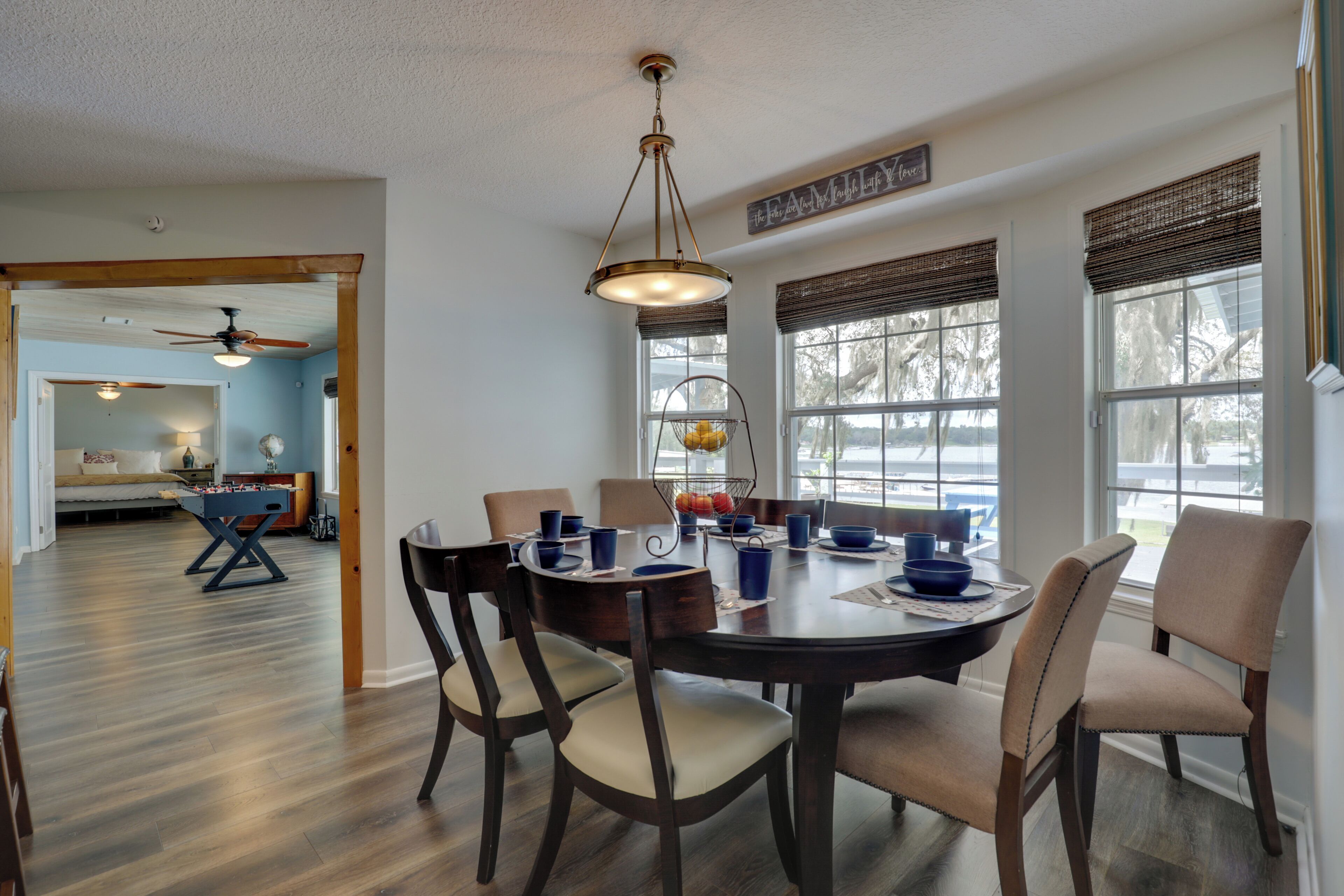 A dining area with a round table, chairs, and a ceiling fan.