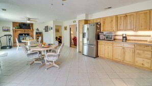 A spacious kitchen with wooden cabinets, a stainless steel refrigerator, and a dining area with a table and chairs. - 2 Mi to Intel: Extended-Stay Retreat w/ Patio (Rio Rancho)