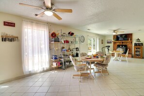 A spacious dining area with a high ceiling fan, a kitchen area with a clock, and a television in the background. - 2 Mi to Intel: Extended-Stay Retreat w/ Patio (Rio Rancho)