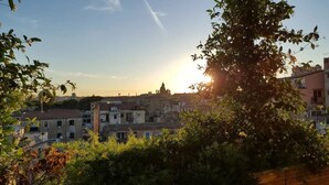 Panorama urbano con edifici e una struttura imponente sullo sfondo.