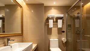 Un baño moderno con un lavamanos grande, inodoro y cabina de ducha de vidrio.
