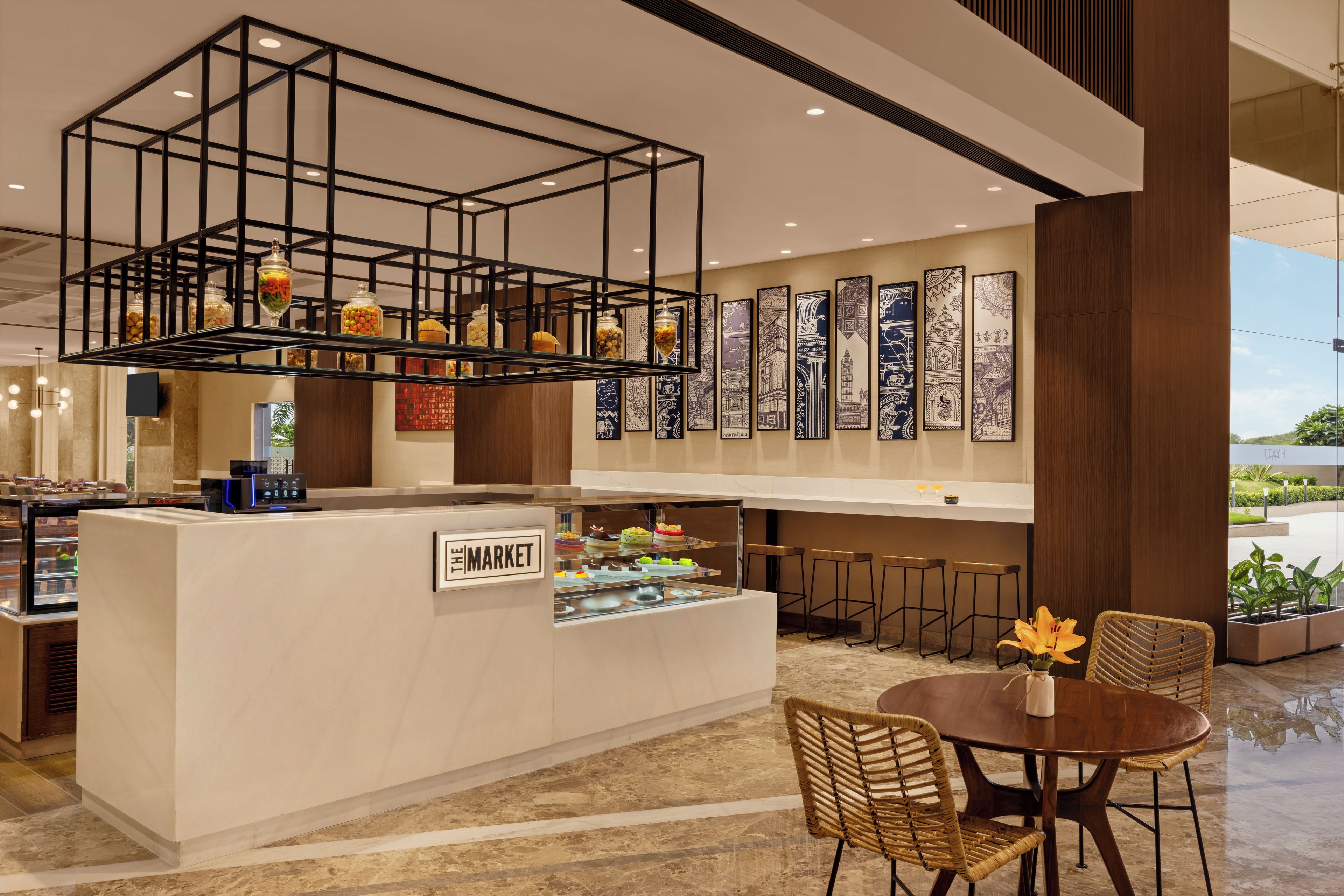 Un café moderne avec un comptoir central, des tabourets de bar et un espace repas comprenant une table ronde et des chaises.