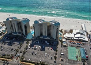 Um hotel moderno com piscina, estacionamento e vista para a praia.
