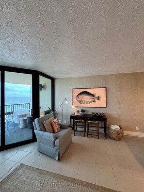 Ein Wohnzimmer mit einer Couch, einem Couchtisch und einem Bild von einem Fisch an der Wand.