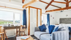 Una habitaci ón con cama, sofá, mesa y ventana con vistas al campo.
