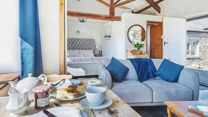 Una habitación acogedora con una cama, un sofá, una mesa de comedor y desayuno, y vistas al exterior.