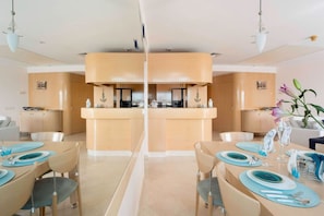 A modern dining area with a central island, two side seating areas, and a kitchen in the background. - Isrotel Tower by Sea N' Rent (Tel Aviv-Yafo)