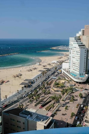 Um hotel à beira-mar com vista para a praia, piscina e estacionamento.