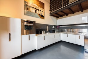 A modern kitchen with stainless steel appliances, white cabinetry, and a large window above the sink. - Isrotel Tower by Sea N' Rent (Tel Aviv-Yafo)