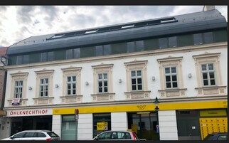 A building with a row of windows, a yellow awning, and a sign that reads 'ÖHLKNECHTHOF'.