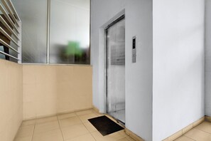A hallway with a door, a window, and a door mat.