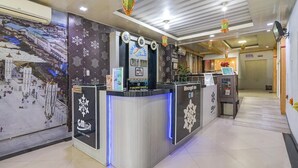 Un espace d’accueil d’hôtel comprenant un comptoir, des éléments décoratifs muraux et un bureau de réception.