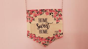 Un letrero colgante con el texto 'HOME Sweet HOME' rodeado de un diseño floral.