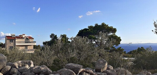 Ein Gebäude mit rotem Dach, umgeben von Bäumen und Felsen.