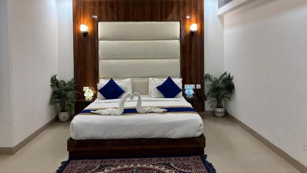 Quarto com uma cama grande, um ventilador de teto e duas luminárias.