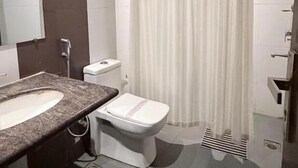 Um banheiro com cortina de chuveiro, vaso sanitário e pia.