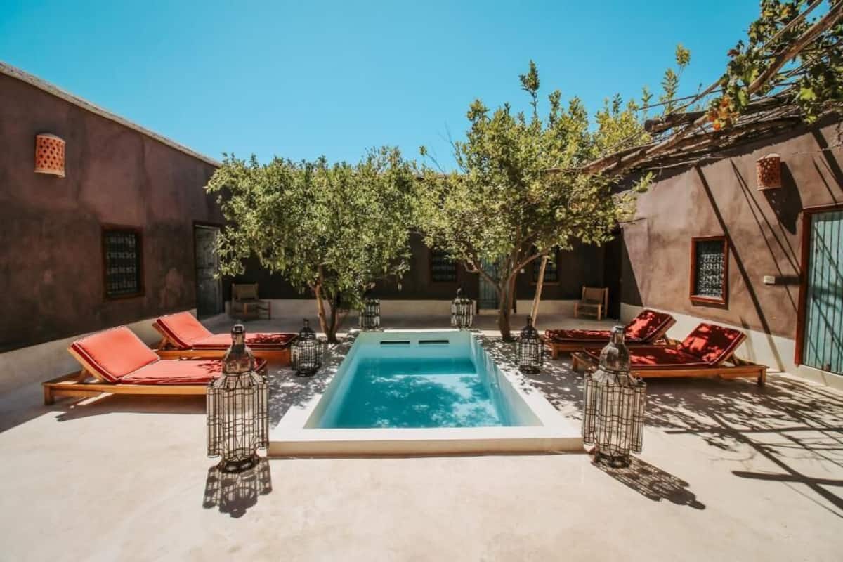 A pool area with lounge chairs and a hot tub.