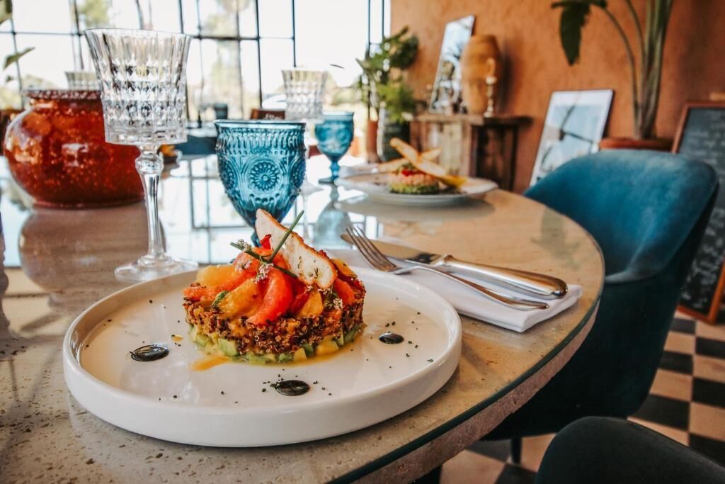 Une table à manger avec une assiette de nourriture, un verre et une fourchette.
