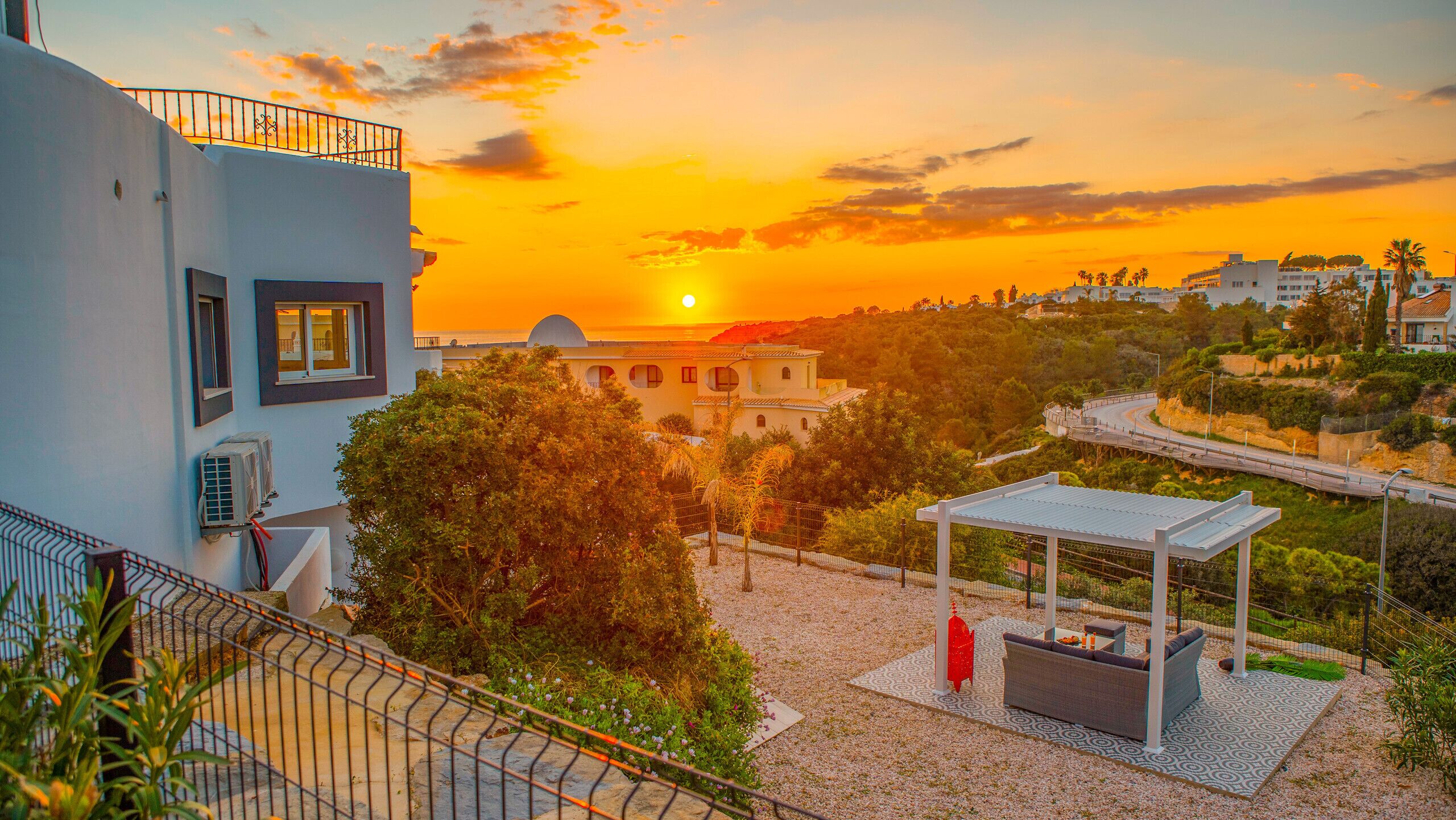 Un quartiere residenziale con vista sul tramonto, un gazebo e un edificio con una cupola.