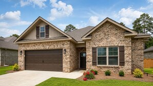 A two-story house with a stone facade, a garage, and a well-maintained lawn.