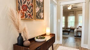 A wooden console table with a vase, a lamp, and a decorative bowl.