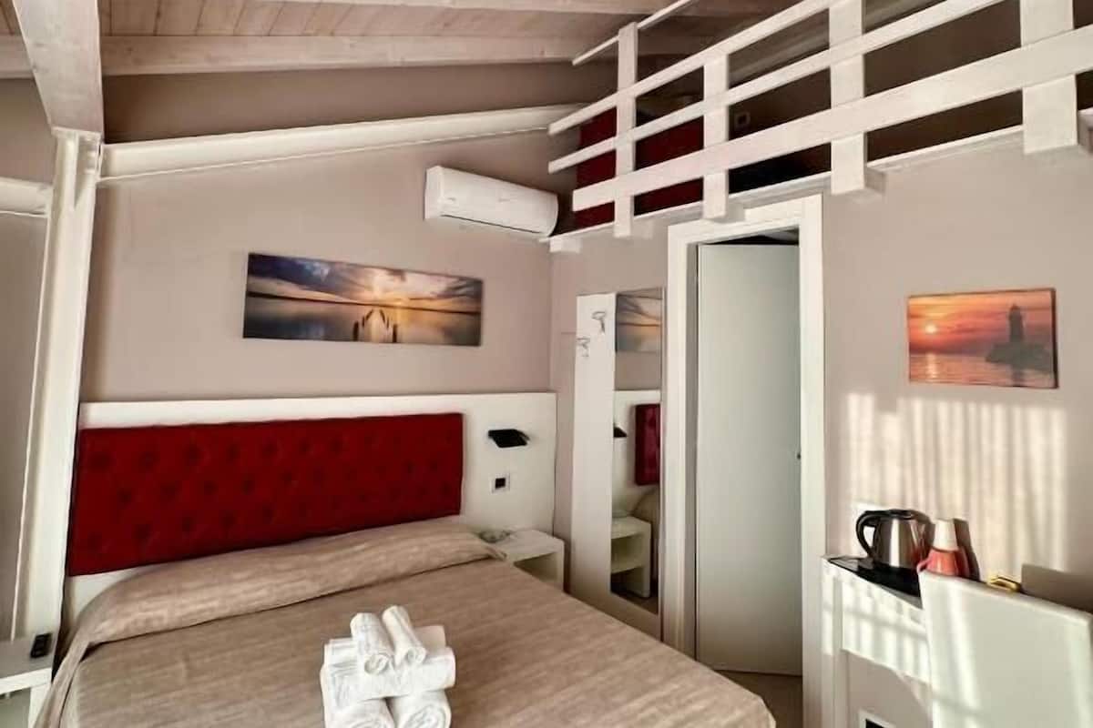 Una camera da letto con un letto, una scrivania e una sedia.