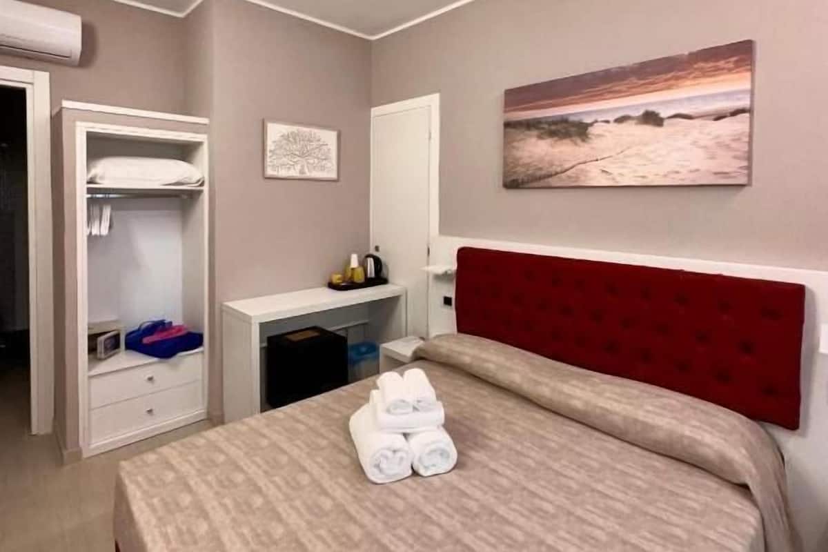 Una camera da letto con un letto, una scrivania e un armadio.