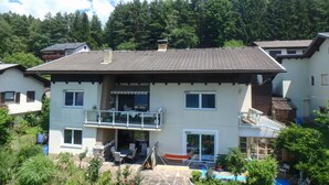 Ein zweistöckiges Haus mit Balkon, Terrasse und Schwimmbad.