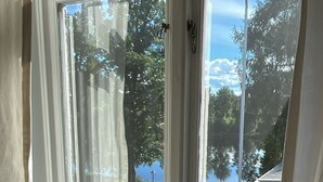 A room with a large window, a radiator below, and a round table. - Husby Wardshus (Dala-Husby)