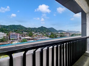 A balcony with a view of a cityscape, including buildings and a green hill in the distance. - Classic Cloud Stay (Guwahati)