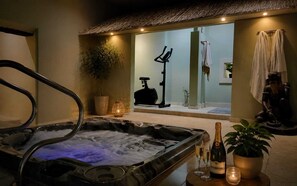 A spa area with a hot tub, exercise equipment, and a bottle of champagne.