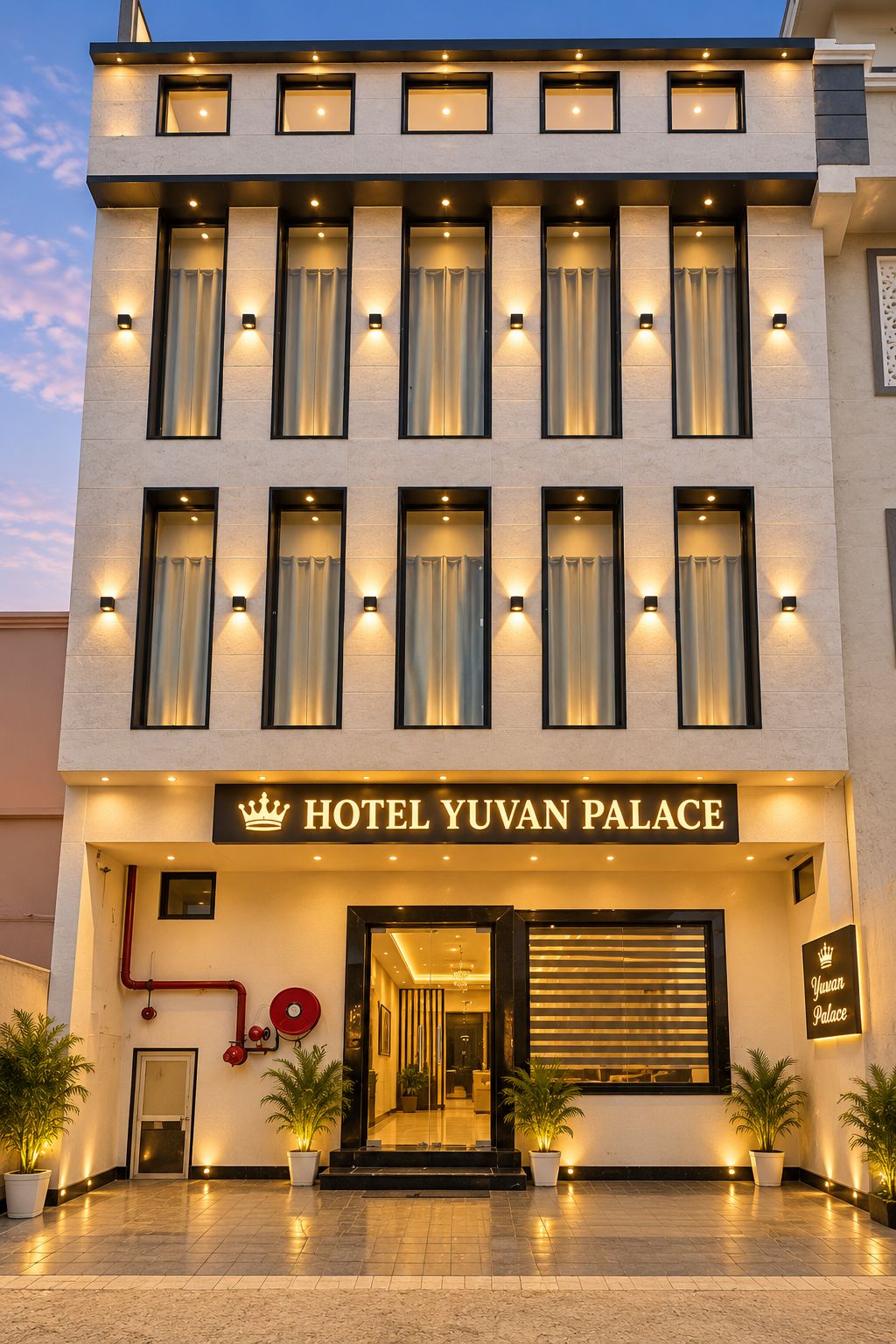 A hotel entrance with a sign reading 'HOTEL YUVAN PALACE' and a modern architectural design.