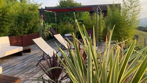 A wooden deck with lounge chairs and a pergola.