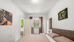 Un dormitorio con cama, ventana y puerta que da a un baño.