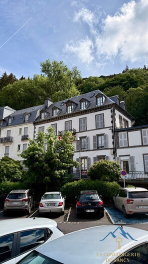 A multi-story building with a traditional European architectural style, featuring a steeply pitched roof and dormer windows. - The Marmot Refuge (Mont-Dore)