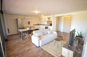 Un appartement moderne comprenant un coin repas, un canapé, une télévision et une cuisine.