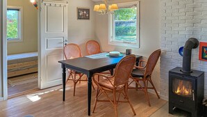 A dining area with a table, chairs, a chandelier, a fireplace, and a view through the window. - Stunning home in Kirke Hyllinge with WiFi (Kirke Hyllinge)