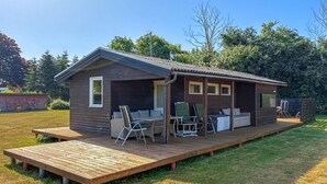 A wooden cabin with a deck, outdoor seating, and a TV. - Stunning home in Kirke Hyllinge with WiFi (Kirke Hyllinge)