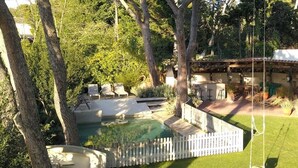 A backyard with a swimming pool, lounge chairs, a deck, and a pergola. - VILLA CANADELL (Palafrugell)