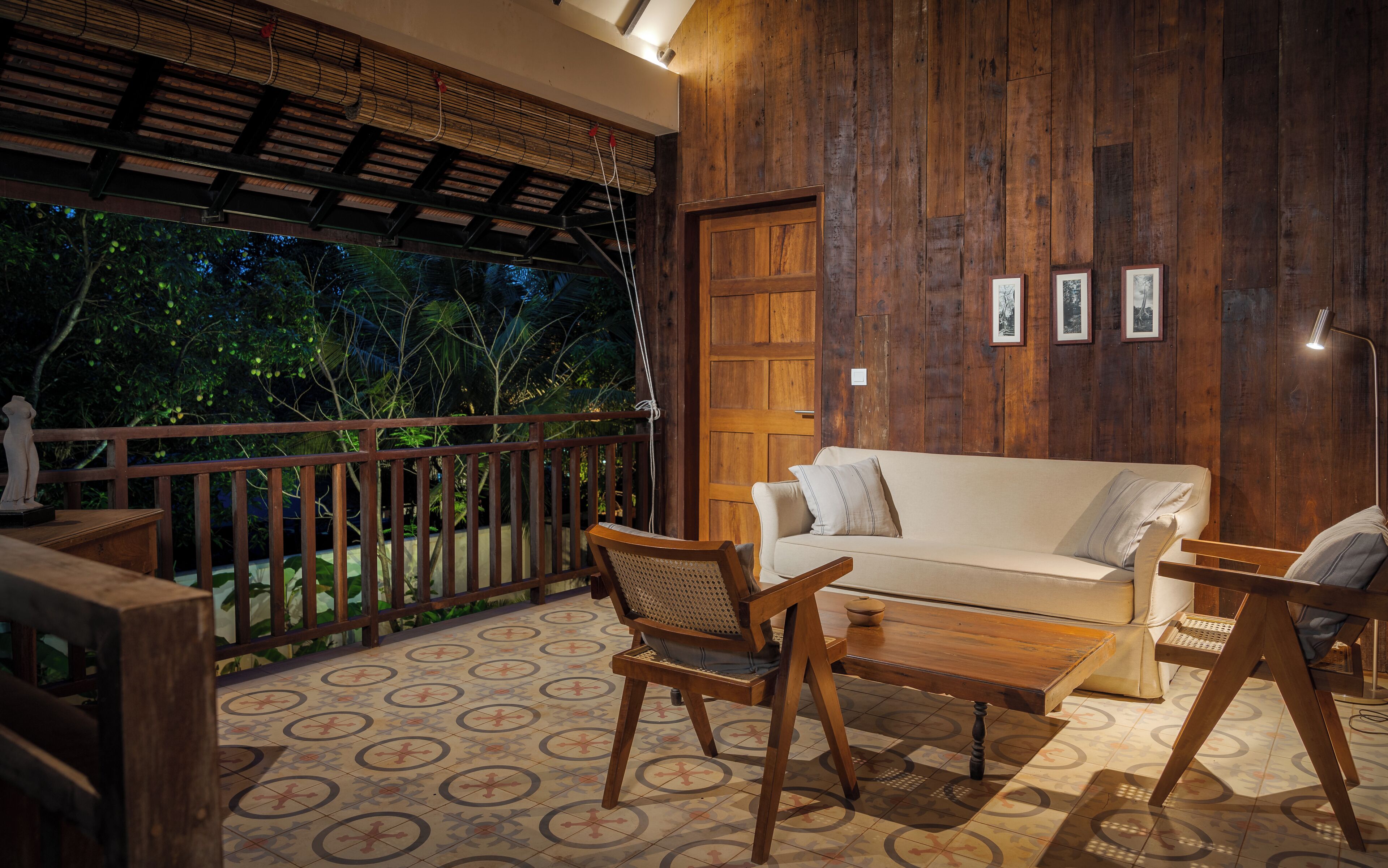 A wooden-floored room with a sofa, chairs, and a table.