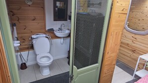 Un baño pequeño con inodoro, lavamanos y espejo.