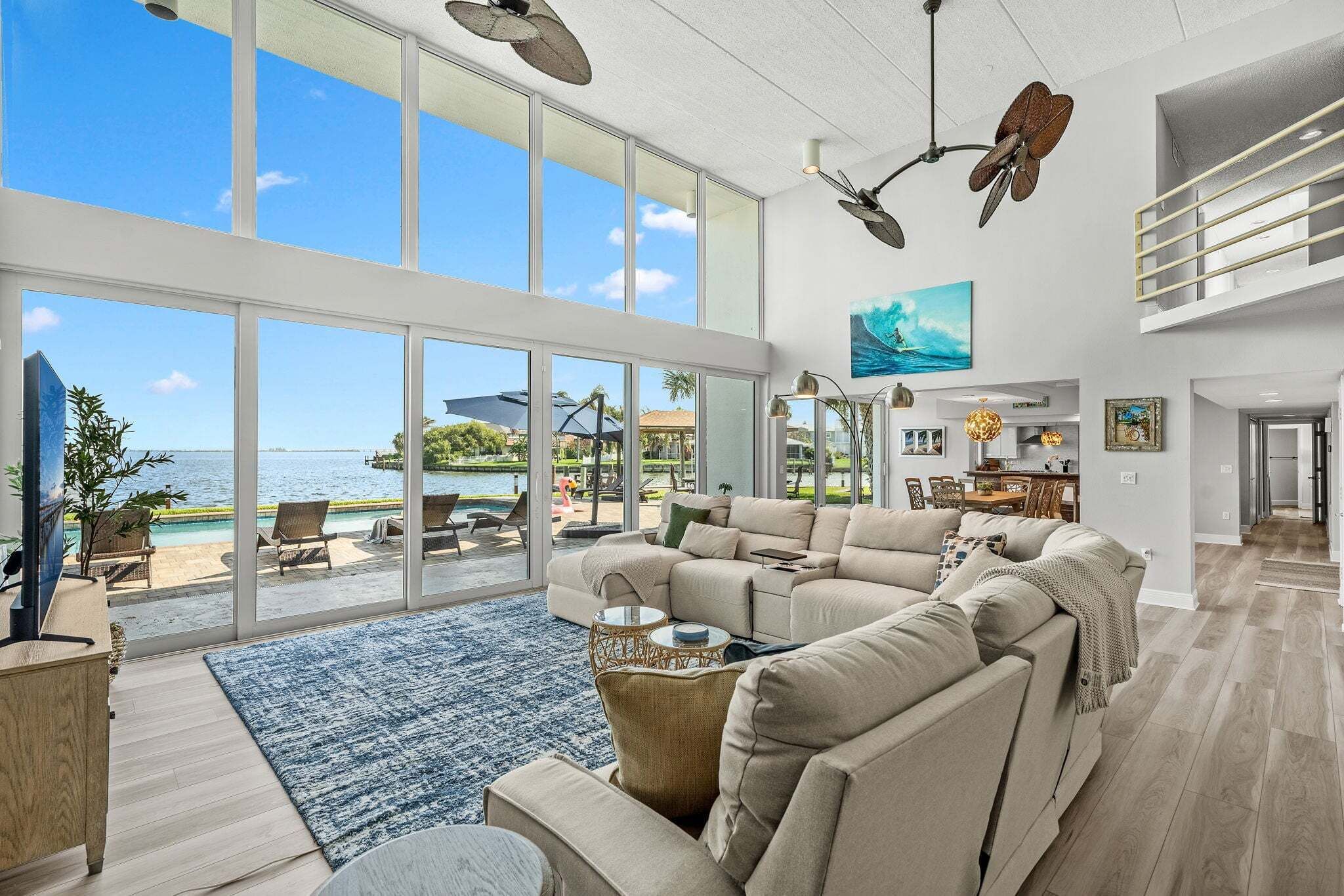 A spacious living room with a large sofa, a coffee table, and a view of the ocean through large windows.
