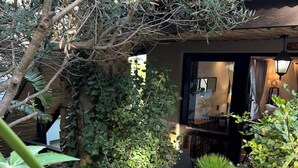 Un espace extérieur aménagé dans un style rustique, avec une clôture en bois, une petite structure en bois et diverses plantes.