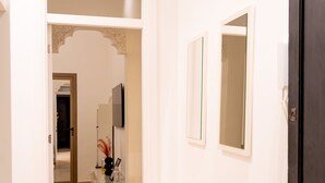 A hallway with a white door, a mirror, and a shelf unit. - Casa Verdi with Terrace, 1 Bedroom, Living Room (Tanger)